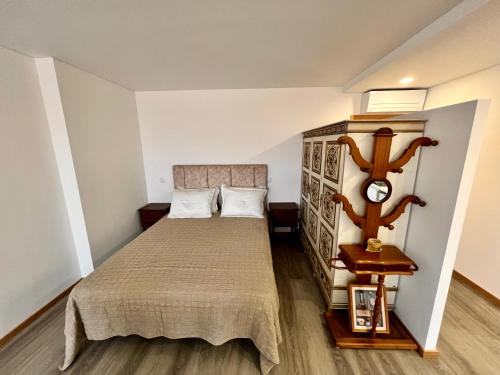 um pequeno quarto com uma cama e um relógio em Charming Studio Apartment in Povoa de Varzim na Póvoa do Varzim