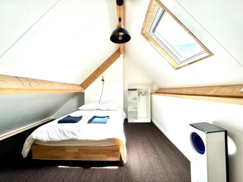 - une chambre mansardée avec un lit et une fenêtre dans l'établissement * Magnifique Chalet entre les pistes et la ville *, à Campan