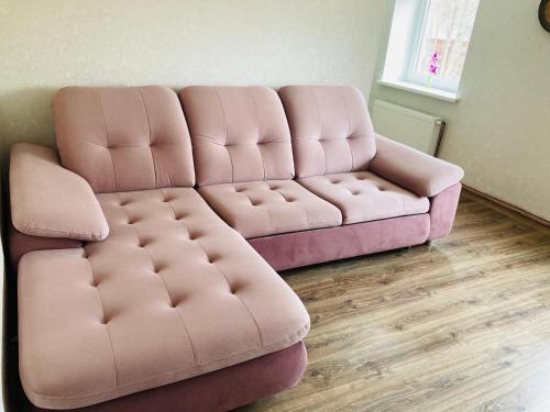 a pink couch sitting in a living room at Nākotnes street apartaments in Liepāja