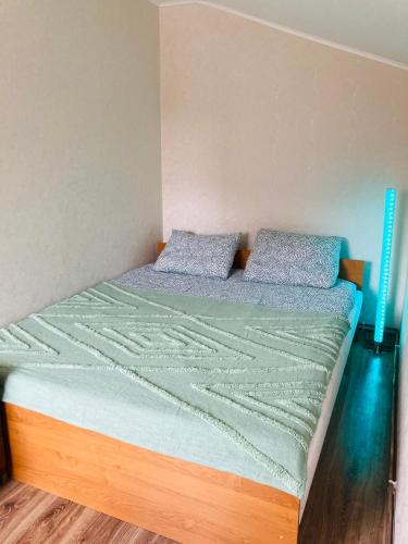a bed with two pillows on it in a room at Nākotnes street apartaments in Liepāja
