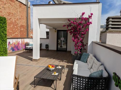 een woonkamer met een bank en een tafel op een balkon bij WEFLATING Fira in Hospitalet de Llobregat