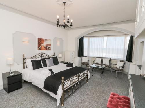 a bedroom with a large bed with a chandelier at Crystal Cove in Bridlington