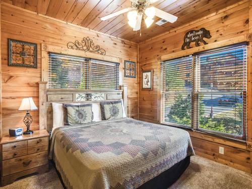 a bedroom with a bed in a room with wooden walls at Heaven's View, 2 Bedrooms, Sleeps 10, Hot Tub, Pool Table, Arcade, Jacuzzi in Gatlinburg