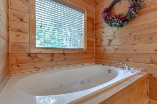 a bath tub in a wooden bathroom with a window at A Mountain Paradise, 2 Bedrooms, Sleeps 6, Pool Access, Hot Tub, Pool Table in Pigeon Forge