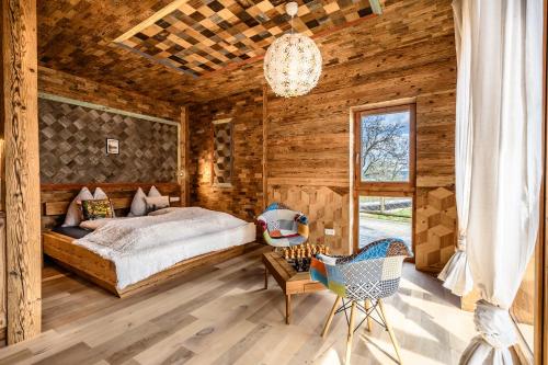 a bedroom with a bed and a chandelier at der baum hideaway in Inzersdorf im Kremstal