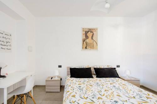 a white bedroom with a bed and a desk at B&B Benvenuti al Nord in Borgomanero