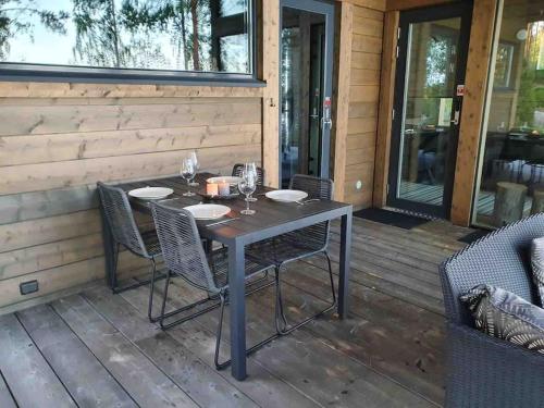 una mesa y sillas en una terraza con porche en Luxury guesthouse, beachfront sauna en Jyväskylä