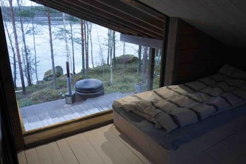 a bedroom with a large window with a stove in it at Luxury guesthouse, beachfront sauna in Jyväskylä