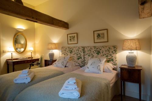 two beds in a room with towels on them at Stackyard Lodge - enchanting 18th Century converted barn in the Waveney Valley in Aldeby