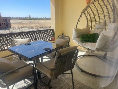 a room with a table and chairs on a balcony at One bedroom marina city portghalib in Port Ghalib