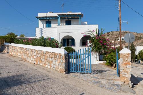 a building with a blue gate and a stone wall at Summer House - Finikas Syros in Víssa