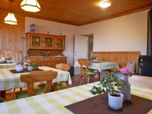 a kitchen and dining room with two tables and chairs at Enzianhuette Jaufenpass in San Leonardo