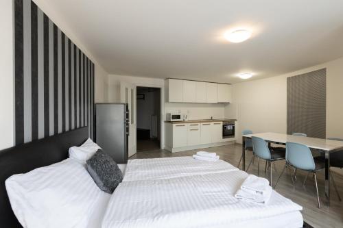 a bedroom with a white bed and a table and chairs at Top Wenceslas Square Apartment in Prague