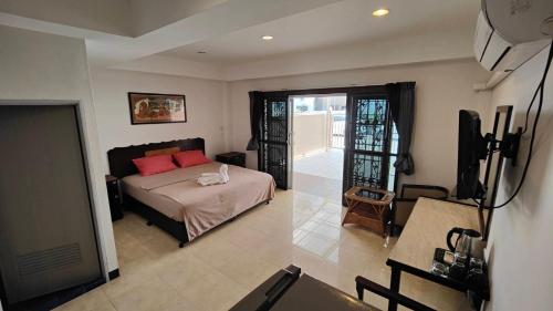 a bedroom with a bed with red pillows and a television at Orient House in Pattaya South