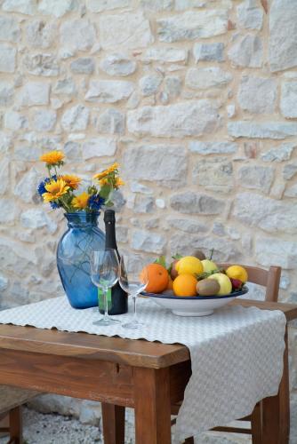 a table with a plate of fruit and a blue vase at Agriturismo Podere del Bosc in Valmareno