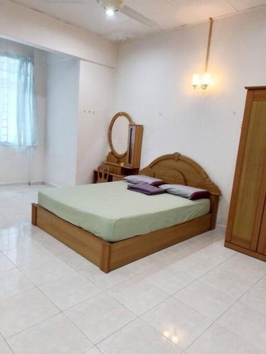 een slaapkamer met een bed en een spiegel aan de muur bij Welcome to Gemas Homestay ALI 