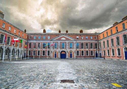 un grand bâtiment avec drapeaux devant lui dans l'établissement Merrion Square Studios, à Dublin