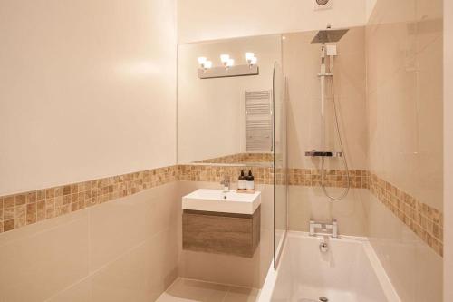 een badkamer met een bad, een wastafel en een douche bij Beautifully decorated centrally located 2 bed flat in Brighton & Hove