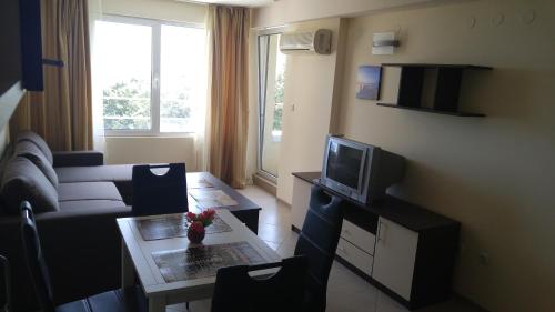 uma sala de estar com um sofá e uma televisão em Europroperties Nikea Park em Golden Sands
