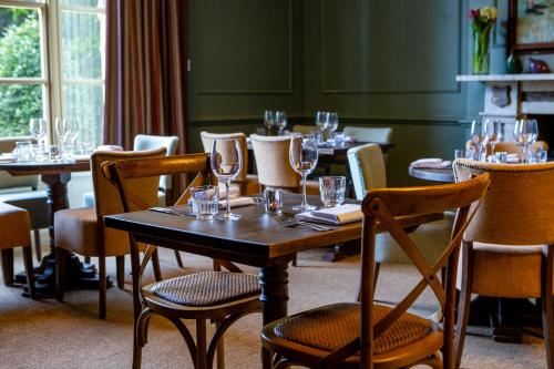 a dining room with tables and chairs with wine glasses at The Barnsdale, Rutland in Oakham