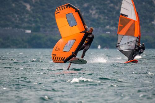 dos personas están haciendo windsurf en un cuerpo de agua en Surf Hotel Pier - Montagnoli Group, en Limone sul Garda