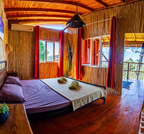 a bedroom with a large bed with red curtains at Olabilir Houses in Ortaca