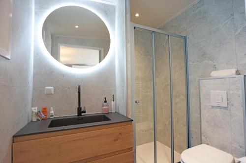 a bathroom with a sink and a shower with a mirror at B&B Schoonhoven Suites in Elim