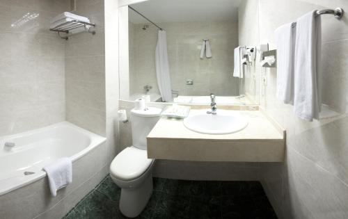 a bathroom with a sink and a toilet and a tub at BQ Andalucia Beach Hotel in Torre del Mar
