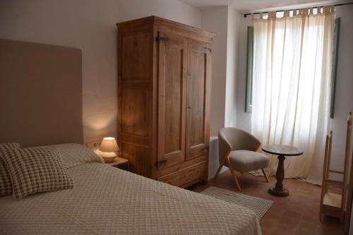 a bedroom with a bed and a cabinet and a chair at Ca La Fesola in Palafrugell