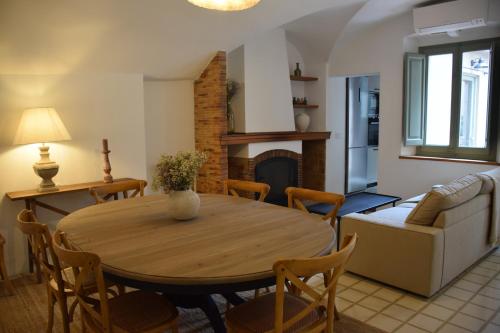 sala de estar con mesa de madera y sillas en Ca La Fesola en Palafrugell