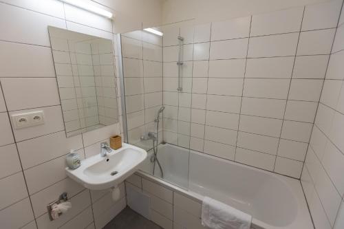 a white bathroom with a sink and a shower at Andel Centre SPIRIT in Prague