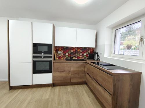 a kitchen with white cabinets and a window at City House - up to 8 Persons in Kapfenberg