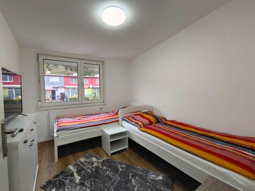 two beds in a room with a window at City House - up to 8 Persons in Kapfenberg