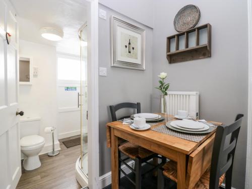 a dining room with a table and a toilet at Cartmel Flat in Grange Over Sands