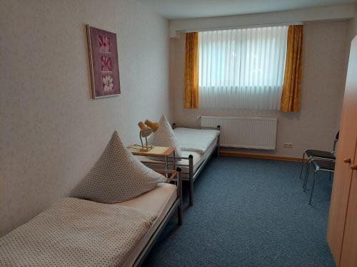 a hospital room with two beds and a table at Cafe-Pension Frey in Baiersbronn