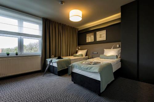 a hotel room with two beds and a window at So Stay Hotel in Gdańsk