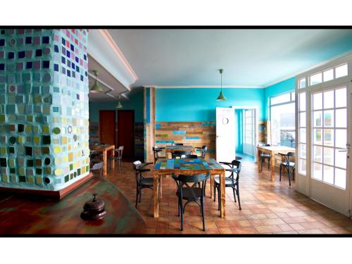 Hotel Langosteira في فينيستيري: غرفة طعام مع طاولات وكراسي وجدران زرقاء