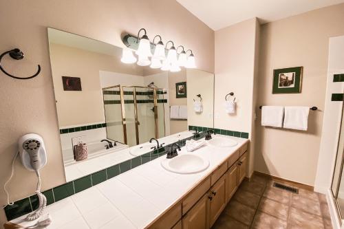a bathroom with two sinks and a large mirror at Northstar 1959 in Keystone