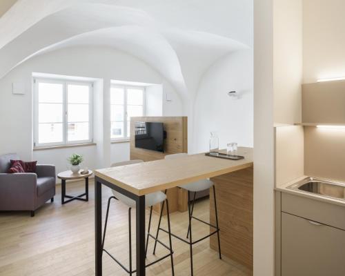a kitchen and living room with a wooden table at Küchlinhaus in Memmingen