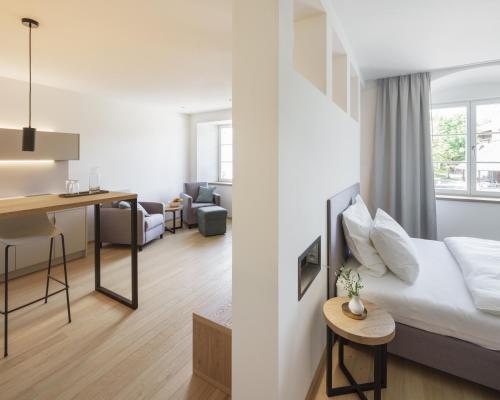a hotel room with a bed and a desk at Küchlinhaus in Memmingen
