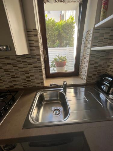 cocina con fregadero y ventana en Sicily one room beach apartment front Eolie islands, en Spadafora