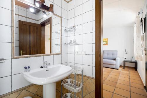 W łazience znajduje się umywalka, lustro i krzesło. w obiekcie Novobarrosa C w mieście Chiclana de la Frontera