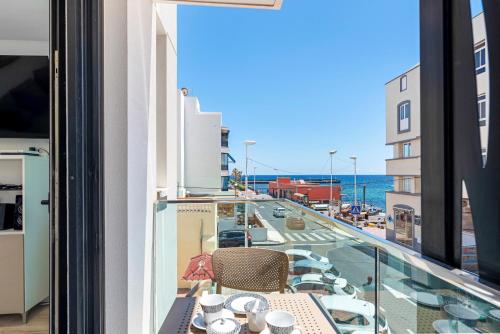 balkon ze stołem i widokiem na ulicę w obiekcie MEDANO4YOU Bogi's Holiday Home w mieście El Médano
