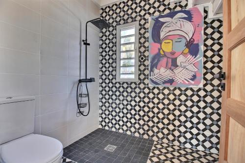 een badkamer met een schilderij aan de muur en een toilet bij Villa Manman Dlo Superbe villa, décoration unique, vue à couperle souffle, piscine privée in Le Marin