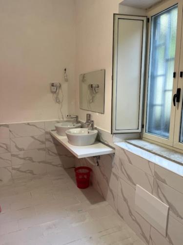 a bathroom with two sinks and a window at Coremi in Naples