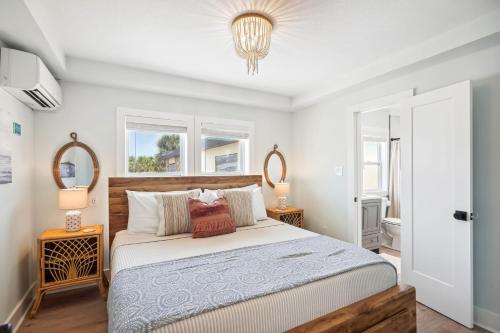 een slaapkamer met een groot bed en 2 spiegels bij Twin Tiki 4 in St Pete Beach