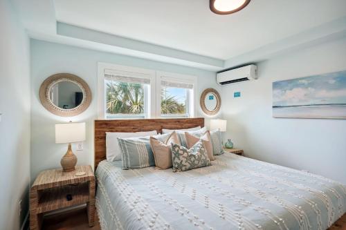 a bedroom with a bed and two windows at Twin Tiki 3 in St. Pete Beach