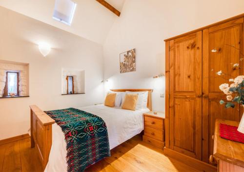 a bedroom with a bed and a wooden cabinet at Beudyr Gelli in Trawsfynydd