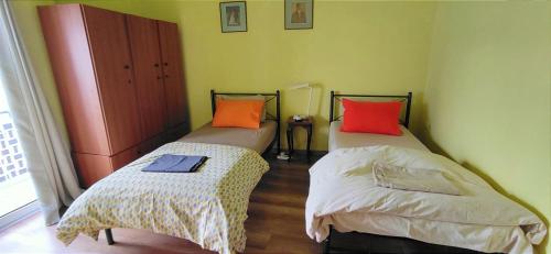 two beds in a small room withacersacers at Cozy μικρό διαμέρισμα κοντά στο λιμάνι in Egina