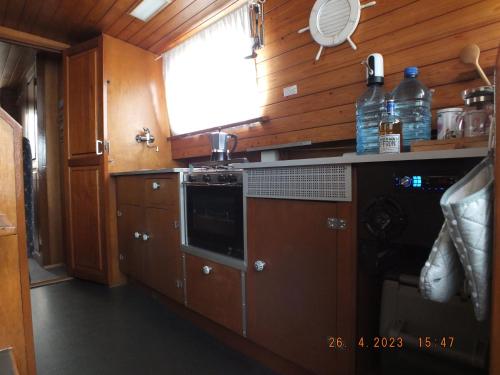 uma cozinha com armários de madeira e um forno com placa de fogão em Zouw Hausboat Zakotven -pouze ubytovaní em Roudnice nad Labem